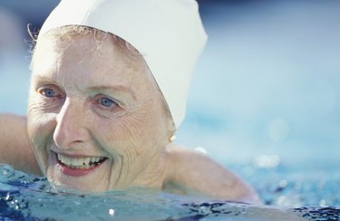 Senior woman swimming in pool, close-up of face