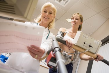 Doctor Monitoring The Heart-Rate Of Patient On A Treadmill
