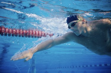 Low angle view of a young man swimming underwater in a swimming pool