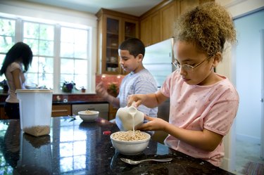 Kids eating cereal in kitchen