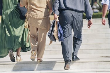 Back view of small group of people climbing steps