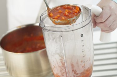 Ladling soup in to a blender, close up