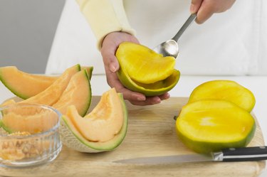 Scooping out the flesh of a mango, close up