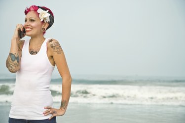 Tattooed Hispanic woman talking on cell phone