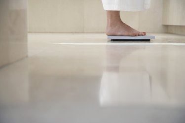 Person's feet standing on a scale