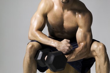 medium shot of a male bodybuilder as he lifts a weight