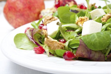 Mix salad with pomegranate, cheese and nuts