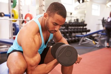 Man exercising with dumbbells at a gym, horizontal shot