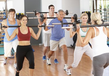 Group Of People Lifting Weights In Gym