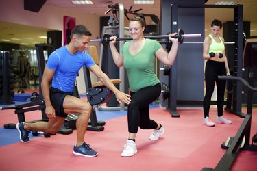 Individual training. Plus sized woman working out with personal trainer