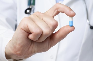 Doctor holding a blue a pill