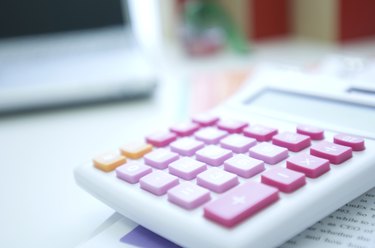 Pink calculator on desk with laptop