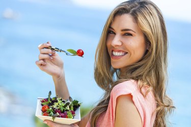 Beautiful woman holding freah salad.