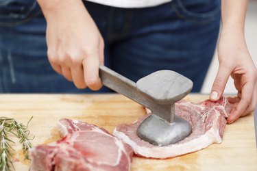 Young woman beating a steak