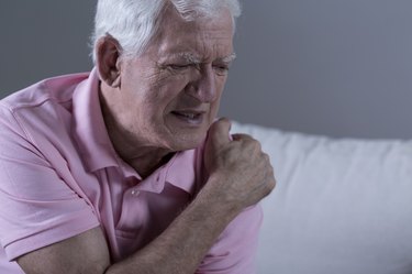 Older adult clutching his shoulder in pain