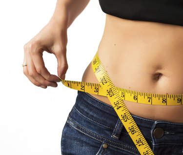 Woman measuring her waistline