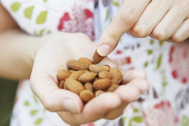 Woman Eating Handful Of Almonds