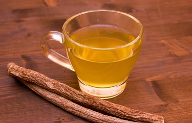 Herbal tea licorice inside cup on wood