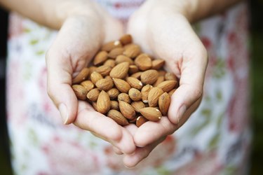 Woman Holding Handful Of Almonds