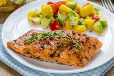 Spice grilled salmon with mango-avocado salsa on a white plate