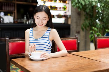 young girl at a cafe drinking coffee