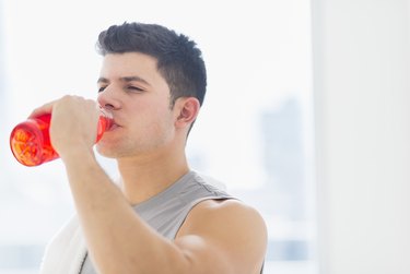 Young man drinking sports drink, Jersey City, New Jersey, USA