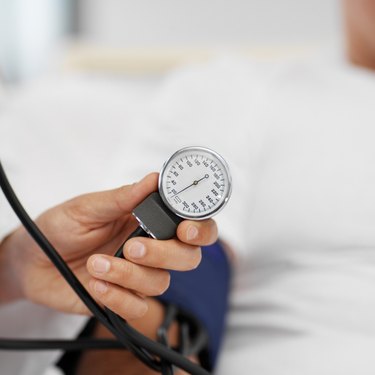 Close-up of doctor taking blood pressure of patient