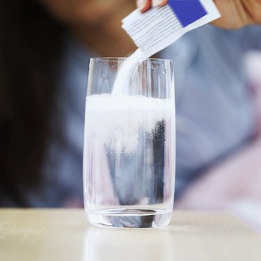 powdered medicine being added to a glass of water