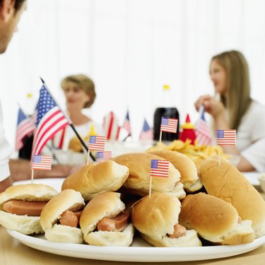 Close-up of a platter of hotdogs dotted with miniature American flags