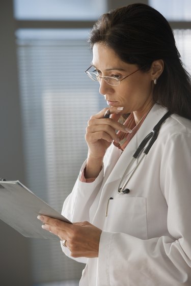Female doctor examining clipboard