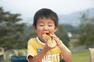 Japanese boy eating a sandwich