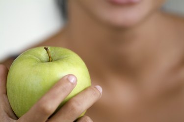 A person holding an apple