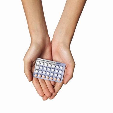 Close-up of woman's hands holding blister packet of contraceptive pills