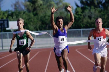 Portrait of male runners crossing the finishing line in a race