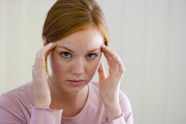 Woman with hands on temples