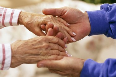 Man holding elderly woman's hands