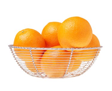 Still life of a glass bowl full of oranges