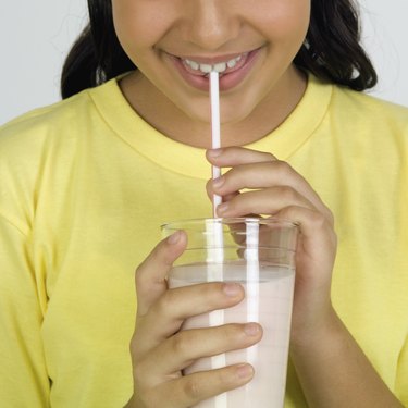 Girl drinking milk, close-up, part of