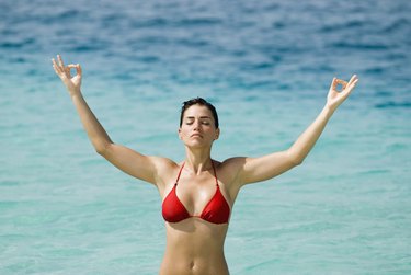 Young woman meditating at beach