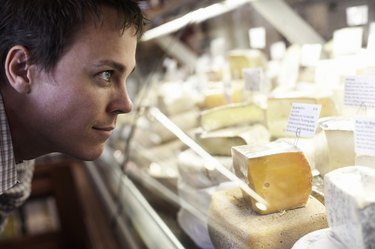 Man Looking at Cheeses