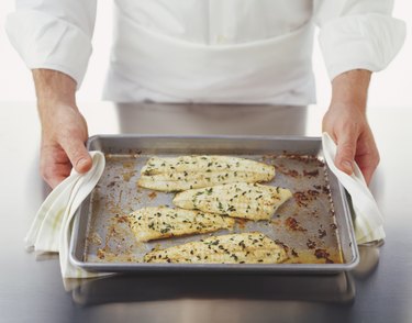 Four pieces of baked plaice fillets on a baking tray