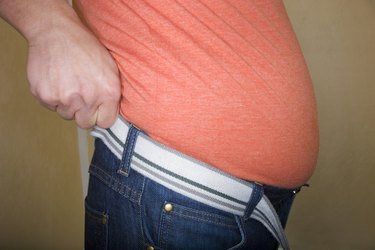 person's midsection pulling up pants