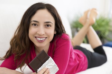 Woman enjoying chocolate while relaxing at home