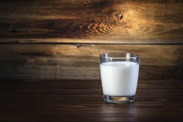 glass of milk on wooden background