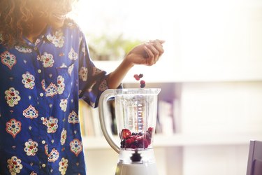 Woman making a smoothie at home.