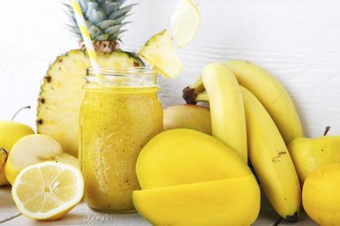 Fresh organic yellow smoothie with banana, apple, mango, pineapple