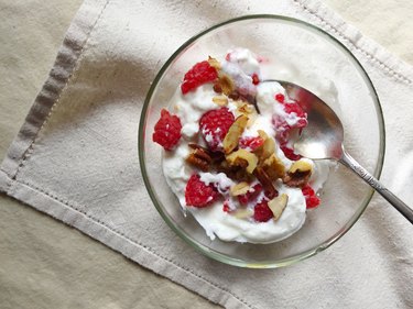 top view of a bowl of yogurt with fresh fruit and nuts.