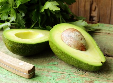 ripe avocado cut in half on a wooden table