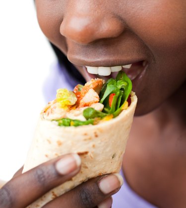 Close-up of a woman eating a wrap