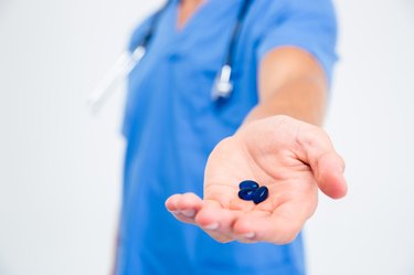 Male doctor holding pills